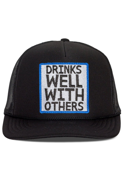 Drinks Well With Others Trucker Hat in Black